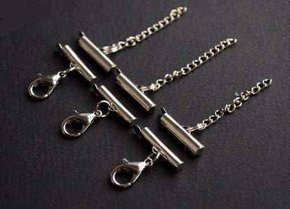 Silver necklace clasps and chains on a black background